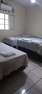 Zimmer mit 2 Betten und einem Fenster in der Unterkunft casa a 5 minutos do aeroporto e Univida in Araraquara