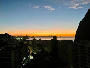 uma vista da cidade ao pôr-do-sol a partir de um edifício em Esplêndido e Aconchegante no Rio de Janeiro