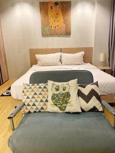 sypialnia z łóżkiem i krzesłem z poduszkami w obiekcie Grand Blue Condominium by Mary w mieście Mae Pim