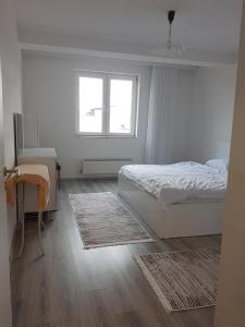 um quarto com uma cama, uma secretária e uma janela em Banesa ne FushKosovë em Pristina