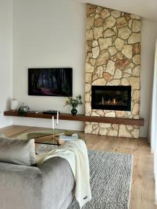 a living room with a couch and a stone fireplace at Cedars Mount View (Adults Only) in Mount View