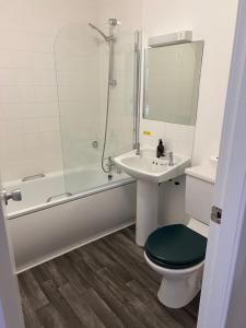 La salle de bains est pourvue de toilettes, d'un lavabo et d'une douche. dans l'établissement Lochailort Inn, à Lochailort