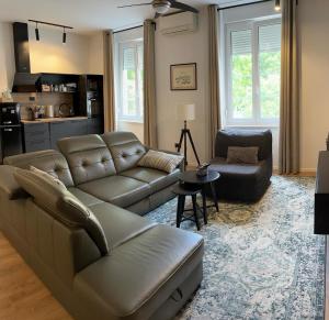 uma sala de estar com um sofá de couro e uma mesa em Apartments INCIS next to the Pula Amphitheather em Pula