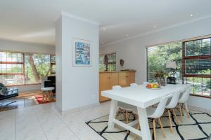 a kitchen and dining room with a white table and chairs at Hout Bay Hilltop in Hout Bay