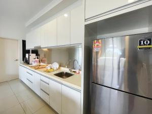 a kitchen with white cabinets and a stainless steel refrigerator at Meridin Medini Near Legoland 5min in Johor Bahru