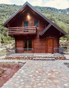 a log cabin with a porch and a deck at Mini Farm Cemi 