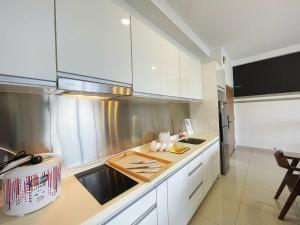 a kitchen with white cabinets and a stainless steel refrigerator at Meridin Medini Near Legoland 5min in Johor Bahru +17 photos