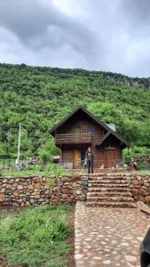 a man standing in front of a log house at Mini Farm Cemi 