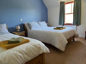 two beds in a bedroom with blue walls at Lochailort Inn in Lochailort