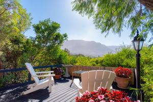 a deck with two chairs and a table and a lamp at Hout Bay Hilltop in Hout Bay