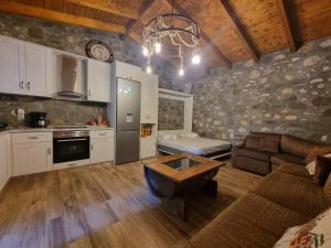 eine Küche und ein Wohnzimmer mit einem Sofa und einem Tisch in der Unterkunft House with big garden and barbeque in nature in Potamiá