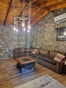 a living room with a couch and a table at House with big garden and barbeque in nature in Potamiá