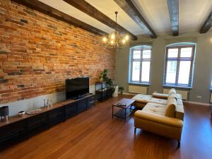 salon z kanapą i ceglaną ścianą w obiekcie Apartamenty Złota Nić w mieście Opole