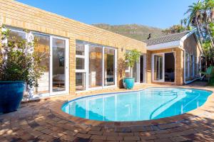 a swimming pool in front of a house at Hout Bay Hilltop in Hout Bay
