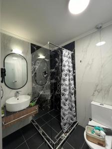 ein Bad mit einer Dusche und einem Waschbecken in der Unterkunft My House Apartments in Pyrgadikia