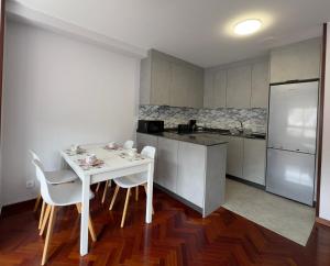 cocina con mesa blanca y sillas blancas en Apartamento a 5 minutos del casco histórico, en Viveiro