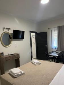 1 dormitorio con cama, espejo y mesa en My House Apartments, en Pyrgadikia
