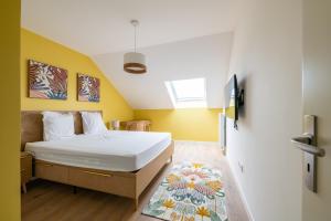 1 dormitorio con cama y pared amarilla en Élégance & Confort pr 6 à Disney - Fairytale Factory en Saint-Germain-sur-Morin