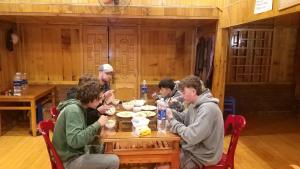 a group of people sitting at a table eating food at MAMA LILI'S HOMESTAY in Hao Su Ngai