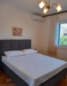 sypialnia z dużym łóżkiem z białymi prześcieradłami w obiekcie Buena Vida Apartman w mieście Zadar