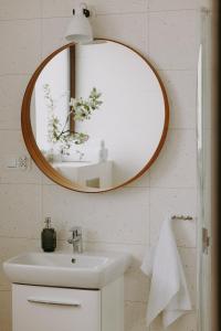 a bathroom with a mirror above a sink at OSADA GRZYBOWSKI MŁYN apartamenty z dużym ogrodem KAISERÓWKA in Grzybowo