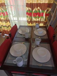 een tafel met borden en bekers erop bij Espina's Residence in Batangas City