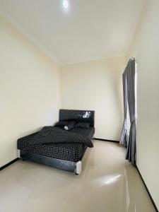 ein Schlafzimmer mit einem schwarzen Bett in einem Zimmer in der Unterkunft Villa Tanjung Alam Batu Syariah in Tlekung