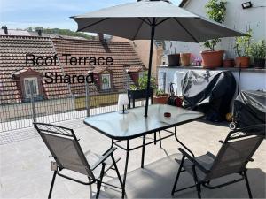 een tafel en stoelen met een parasol op een patio bij C&A Apartments in Kaiserslautern