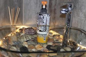 eine Glasschüssel voller Steine und eine Flasche Öl in der Unterkunft Kuredu / Uroa w Krainie Alicji in Lyck