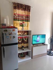 een keuken met een koelkast en een televisie bij Espina's Residence in Batangas City