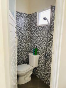 ein Badezimmer mit Toilette und Dusche in der Unterkunft Villa Tanjung Alam Batu Syariah in Tlekung
