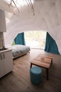 una camera con letto e tavolo di Glamping Machakhela a Ch'ik'unet'i