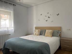 a bedroom with a bed with birds on the wall at Apto céntrico CASA CONCHA VUT 47-127 in Valladolid