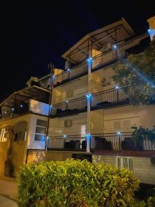 um edifício com luzes azuis à noite em Apartments Villa Ivanka em Trogir