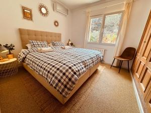ein Schlafzimmer mit einem Bett, einem Fenster und einem Stuhl in der Unterkunft Denia Dream Seaview Golf, Tennis & Beach Villa in Muntanya la Sella