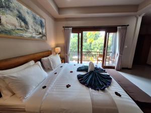 - une chambre avec un grand lit et une grande fenêtre dans l'établissement Bambu Lokha Guest house, Gianyar Bali, à Ubud