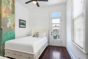 a white bedroom with a bed and a window at Private 2BR Condo in Uptown by Hosteeva in New Orleans
