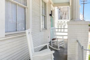 Dos mecedoras sentadas en el porche delantero de una casa en Private 2BR Condo in Uptown by Hosteeva, en Nueva Orleans