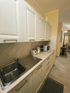a kitchen with white cabinets and a sink at Tra i due ponti in Bosa