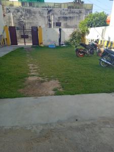 two motorcycles parked in a field of grass at Anaya Guest House Etah in Etah +12 photos