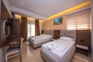 Habitación de hotel con 2 camas y escritorio en Hotel New Crystal, en Ksamil