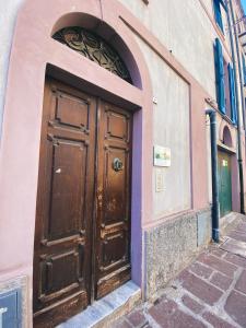 a large wooden door on the side of a building at Tra i due ponti in Bosa +39 photos