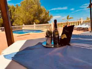 a table with a bottle of wine and a glass at Denia Dream Seaview Golf, Tennis & Beach Villa in Muntanya la Sella