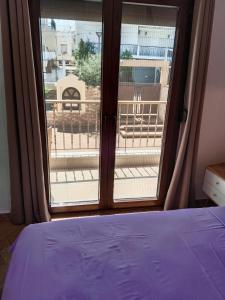 a bedroom with a window with a view of a balcony at theasis1 in Neos Marmaras