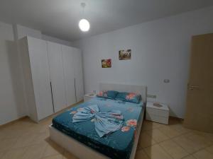 Schlafzimmer mit einem Bett mit blauer Decke in der Unterkunft Beach view Apartment in Vlorë