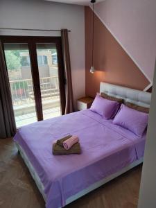 a bedroom with a purple bed with a towel on it at theasis1 in Neos Marmaras