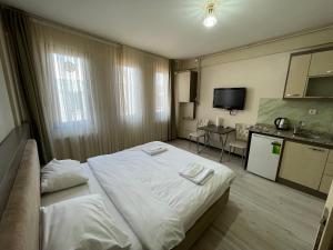 イスタンブールにあるDizayn Otelの大きなベッドとキッチンが備わるホテルルームです。