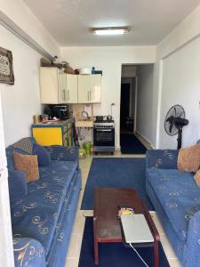 アインソフナにあるقرية بلاجيو العين السخنةの青いソファとテーブルのあるリビングルーム