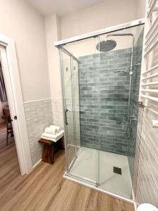 Un baño con ducha con mampara de cristal. en Main Beach - Lavalle Apartamentos, en Loredo