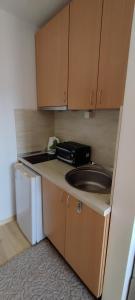 a small kitchen with a sink and a microwave at Anchors Guest House in Sozopol